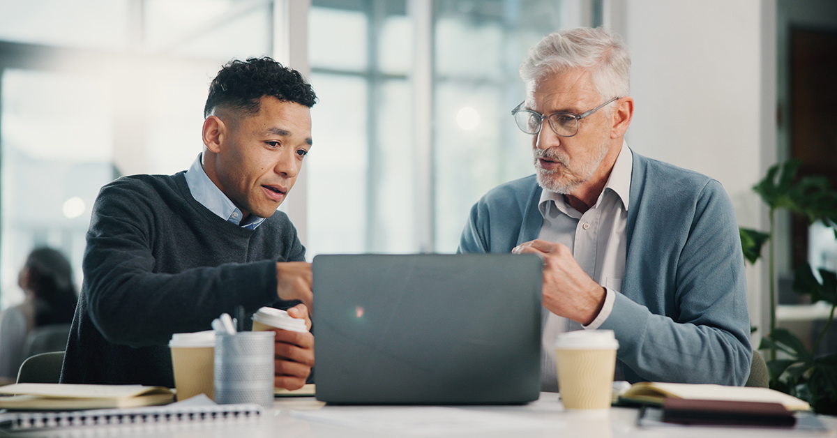 Financial advisor and client sitting together, reviewing printed documents in a professional setting.